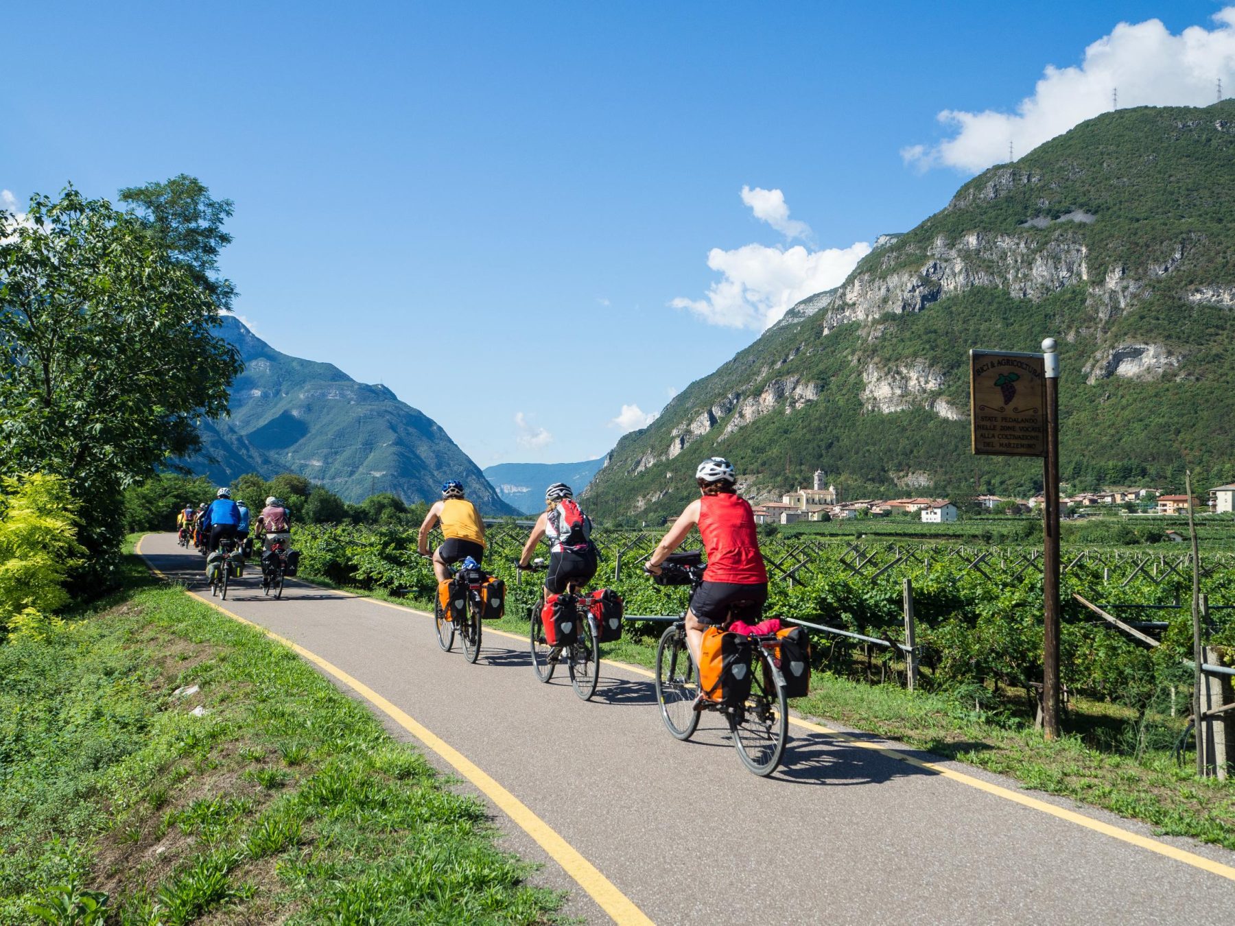 Mensen tijdens een fietstocht door een bergachtig landschap in Trentino.