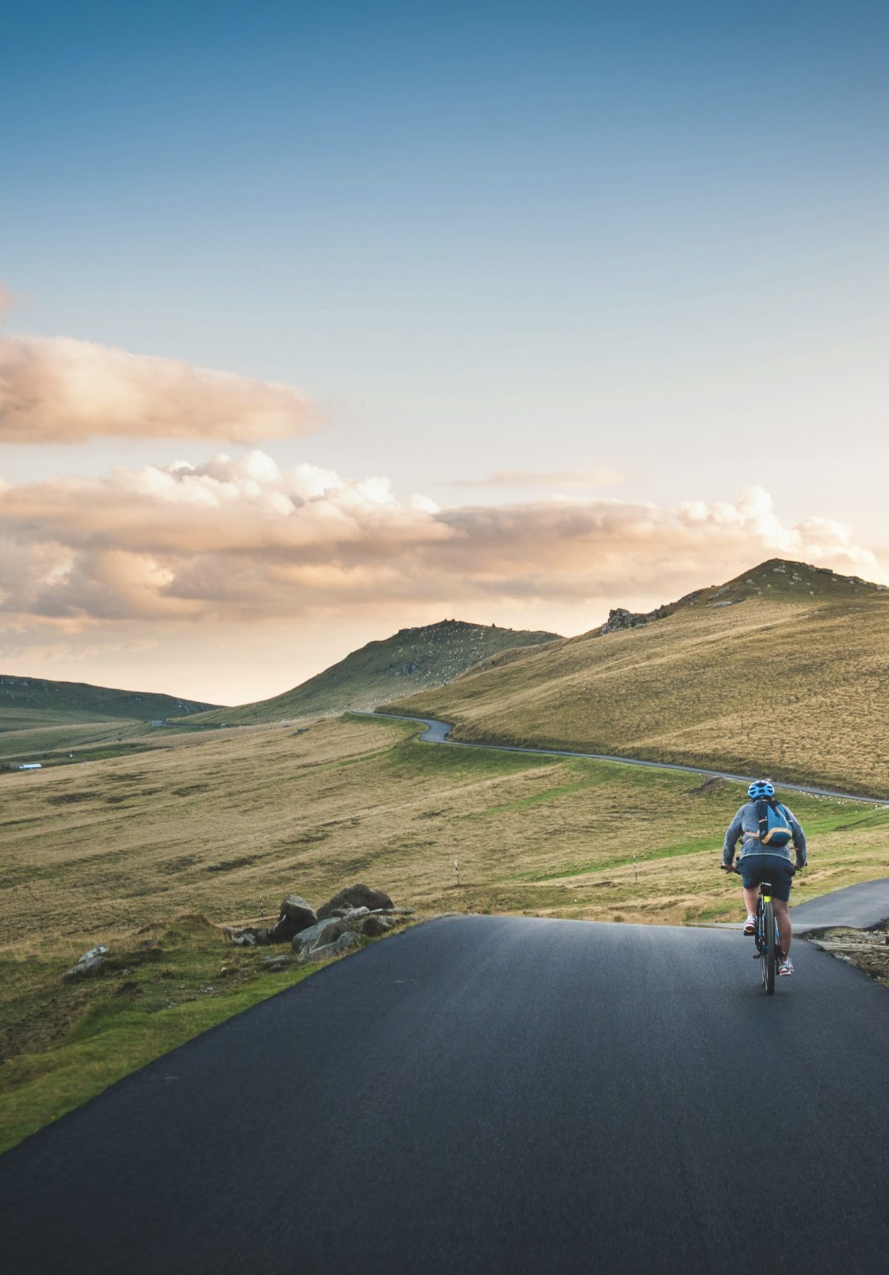 Een persoon fietst overdag door een bergachtig landschap.