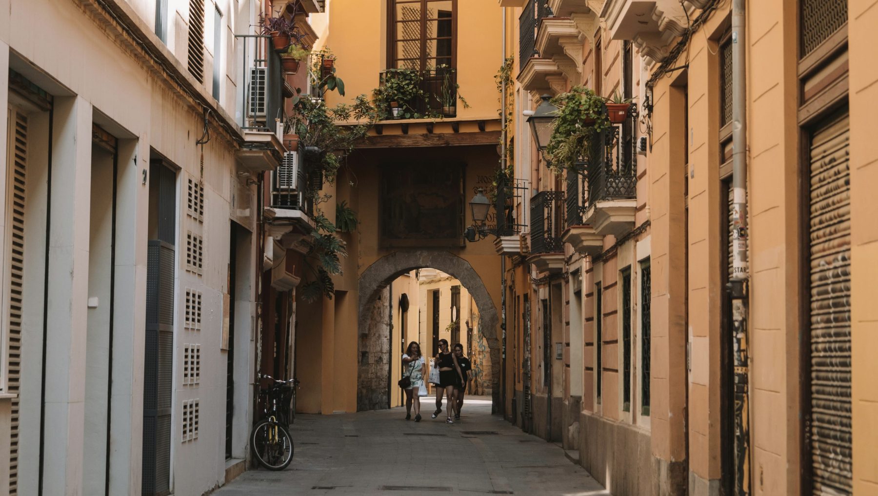 Een aantal mensen wandelend door de straatjes van het oude centrum van Valencia.